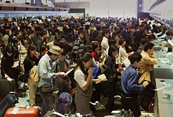 Holidaygoers line up at airline check-in counters at New Tokyo International airport, Narita. Travel firm rapped over foreigner ticket policy