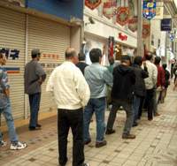 Pachinko fans (and perhaps others paid to reserve a “lucky” machine for a client) wait for a parlor in Tokyo to open. Patience pays off for firms on standby to queue for you
