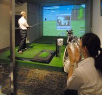 Tee time: A Shirokane Club “caddy” applauds a patron’s drive down the golf bar’s virtual fairway. Get into golf's virtual swing