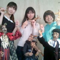 Play school: Students in Jesse Glass’ English literature class at Meikai University hold puppets of the Devil King (left), the Fiddling Devil (center) and Faustus, which they use to present their professor’s original work, “Faustus and the Golden Keitai.” Break on through (to the puppet side)