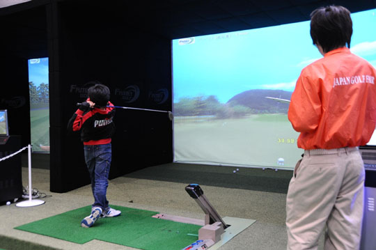 Taking a swing: A boy practices virtual golf at last year’s Japan Golf Fair. Golf Fair shoots above par