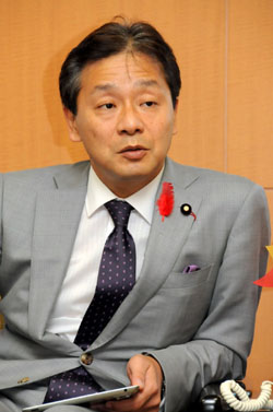 High finance: Ikko Nakatsuka, the newly appointed state minister for financial issues, is interviewed by a group of reporters Friday. Government will take its time deciding on reporting standards, Nakatsuka says