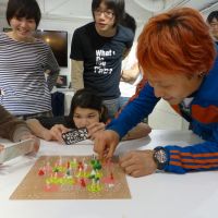 Making ideas come to life: Designer Kota Nezu (right), turns cogs adorned with objects created by participants during a 3-D printing and modeling workshop held recently at the FabCafe in Tokyo’s Shibuya district. TOMOKO OTAKE PHOTOS Local 3-D printing pioneers make it easy for all to join in