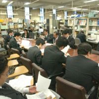 Journalists face eBANK Corp. officials across a table at a news conference at the BOJ press club Thursday. In the background, other press club members work at booths cluttered with files and papers. Press clubs: Exclusive access to, pipelines for info