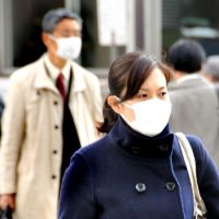 Little protection: People wear surgical masks in Tokyo’s Marunouchi district. Flu prevention advice nothing to sneeze at