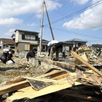 Seaside scenes: Volunteers clean up an area devastated by tsunami in Asahi, Chiba Prefecture, on Monday. Tsunami came late to unprepared Chiba