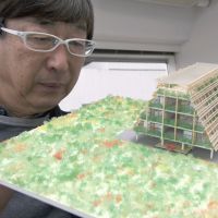 Solutions: Toyo Ito of Toyo Ito & Associates, Architects, looks at a model of his redevelopment project that is being examined by the city of Kamaishi, in Iwate Prefecture, at his Tokyo office on Feb. 22. Island fortresses floated for Tohoku