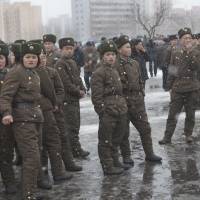 In it together: North Korean soldiers gather on the streets of a snowy Pyongyang on Sunday. North Korean internment camps 'a Holocaust in progress'