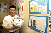 Hector Sierra holding up the daruma made by Japanese and American children Drawing on their experiences