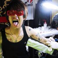 A young man gets a tattoo at a convention. Japanese tattoo art carves its mark in the mainstream
