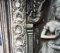 A worker looks out from a Cambodian temple at Angkor Wat. Power and glory of temple ruins