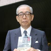 Nobuyuki Nakahara, a former member of the Bank of Japan Policy Board, poses last month in Tokyo with his book Who Does the BOJ Belong To? BOJ repeating history, board exec from 2000 warns