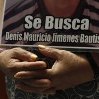 Wanted back: A member of a caravan of Central American mothers hold a photograph of her missing son during a Mass at the Basilica of Guadalupe in Mexico City in October. Mexican police, soldiers tied to disappearances