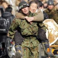 She ain’t heavy: A member of the Japan Ground Self-Defense Force carries an elderly woman on his back as people are evacuated to a shelter at Kesennuma city in Miyagi Prefecture on March 12, 2011. Data collected during the initial stages of the 3/11 disaster could help focus such rescue efforts in future disasters. Data from 3/11 could save lives if used effectively
