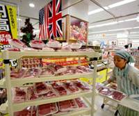 More on the table: A clerk prepares imported meat Tuesday for a “high yen” sale at an Ito-Yokado supermarket in Tokyo. Hawaii holidays, Tiffany jewelry get yen boost