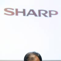 Hard choices: Takashi Okuda, president of Sharp Corp., pauses during a news conference Thursday in Tokyo. The maker of Aquos TVs said it will cut 5,000 jobs after widening its annual loss forecast to ¥250 billion as demand for its sets slumps. Sharp needs Hon Hai ties, if only for Apple