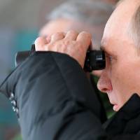 Appeased: Russian President Vladimir Putin watches a military exercise in the Black Sea resort of Anapa on Friday. Russia tones down anger but questions remain over bailout