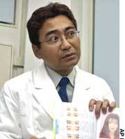 Plastic surgeon Toshiya Handa of Otsuka Academy of Cosmetic and Plastic Surgery displays a cosmetic surgery catalog at his clinic in Tokyo. Plastic surgery makeovers luring the insecure