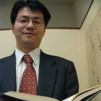 Fumiaki Isogae, a lawyer specializing in child-abuse cases, holds open a legal text at his office in Shinjuku Ward, Tokyo. Child-guidance centers lacking: experts