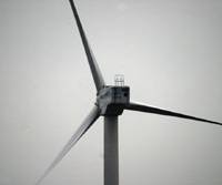 A wind turbine spins away on the coast of Kanagawa Prefecture. Proponents of renewable energy want Japan to switch away from nuclear power. All cost bets off if Big One hits nuke plant