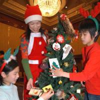 Asuka Uozumi, 12, her brother, Kenta, 9, and their mother, Keiko, trim a Christmas tree during a decoration contest last December at Sheraton Grand Tokyo Bay. Japan has its Christmas cake and eats it, too