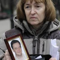 Silenced: Nataliya Magnitskaya holds a portrait of her son Sergei Magnitsky, who died in jail in 2009. He was arrested on tax evasion charges after he alleged Russian officials and organized criminals conspired to claim $230 million in tax rebates. Are Russian assassins on the streets of Britain?