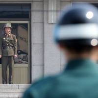 Uneasy peace: Soldiers from North Korea (left) and South Korea stand guard on their respective sides of the border at the truce village of Panmunjom in the demilitarized zone dividing the two countries on Thursday. As North Korean crisis rumbles on, how far is too far?