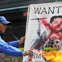 Smoky bacon: A South Korean activist burns a caricature of North Korean leader Kim Jong Un at a rally Thursday in Seoul. Young Kim pushing harder than ever