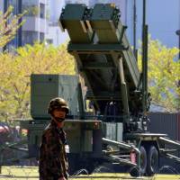 Covering all bases: A soldier of Japan’s Ground Self-Defence Force patrols near a Patriot Advanced Capability-3 (PAC-3) missile launcher deployed at the Defence Ministry in Tokyo on April 11, in anticipation of an expected mid-range missile launch by North Korea. Tabloids sharpen claws for North Korea's 'X-Day'