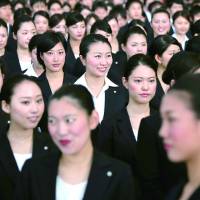 Japan Airlines Co. (JAL) group companies' new employees attend a welcoming ceremony at the company's hangar near Haneda Airport in Tokyo on April 1. Saving Japan: promoting women's role in the workforce would help