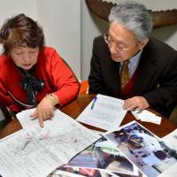 For the fallen: Heitaro Matsumoto and his colleague, Sumiko Naito, who have volunteered to repatriate the remains of fallen Japanese soldiers, show documents of their work during an interview in Tokyo on Feb. 5. Hunt for war remains never-ending