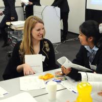 Broadening horizons: A Harvard University student chats with Japanese high schoolers during a gathering held as part of the Harvard College in Asia Program in Shibuya Ward, Tokyo, on March 21. High schoolers dream of Ivy League