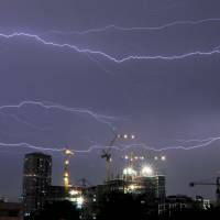 Bolt out of the blue: Horizontal lightning flashes across the night sky above a construction site in Bangkok during a storm. Proof of 'dark lightning' uncovered