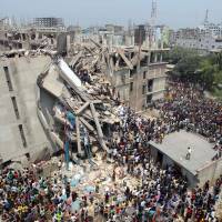 Looking to help: People gather after an eight-story building collapsed in Savar, near Dhaka, on Wednesday. Warnings on Dhaka building ignored