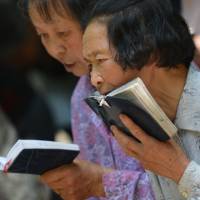 Believers: Catholics pray at Our Lady of Sheshan Basilica Catholic Church in Shanghai on Friday. On Sunday, police in Donglu, Hebei Province, stopped pilgrims from joining a Catholic parade to honor the Virgin Mary, whom locals say appeared in the village a century ago. China pilgrims barred from Catholic parade