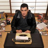 Keyed up: Jake Adelstein at home, surrounded by magazines and books on the criminal underbelly of Japan he has come to know so well. Insider reaching out