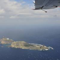 Prime real estate: One of the Senkaku islets is seen from a Chinese B-3837 marine surveillance plane that intruded into Japanese airspace above the East China Sea chain Dec. 13, further escalating the bilateral sovereignty dispute. China takes Senkakus row to U.N.