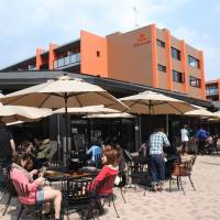 Carefree life: Students dine and socialize in the outdoor cafeteria at the College House Fuso dormitory on Takushoku University's Hachioji campus on April 15. Universities lure students with upscale dorms