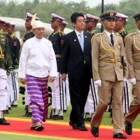 Doing the rounds: Prime Minister Shinzo Abe and Myanmar President Thein Sein inspect the honor guard at the Presidential Palace on Sunday in Naypyitaw. Abe pledges more aid to Myanmar