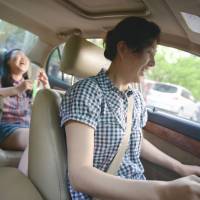 Bourgeois dreams: Li Na shares a light moment with her daughter as she drives home in Beijing on May 12. Fears dog China's rising middle class