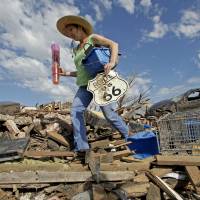 No kicks on Route 66: A resident of Moore, Oklahoma, salvages items from a friend’s tornado-ravaged home on Wednesday. Most buildings in 'Tornado Alley' lack shelters