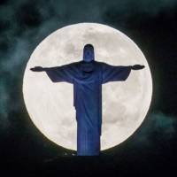 Lunar light show: The moon sets behind the Christ the Redeemer statue in Rio de Janeiro on Saturday. Moon may harbor alien minerals