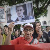 Rallying figure: Protesters shout slogans in support of former U.S. National Security Agency contractor Edward Snowden as they march to the U.S. Consulate in Hong Kong on June 13. Snowden files stoke U.S. security concerns