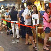 Dem bones: Consumers line up to get their paws on a Hello Kitty character toy in a skeleton outfit at a McDonald's restaurant in Singapore on Thursday. Singapore gripped by 'Singing Bone' Hello Kitty frenzy