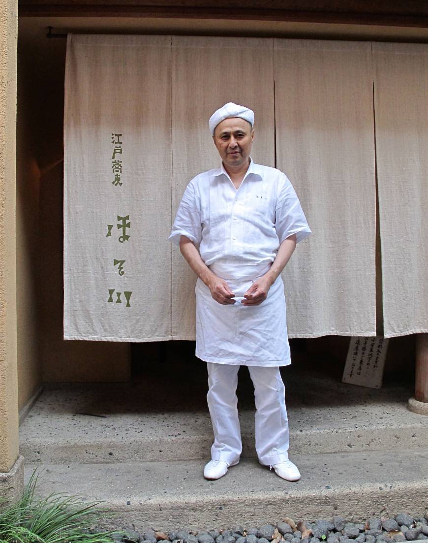 Hosokawa In good hands: Soba master Takashi Hosokawa stands in front of his eponymous noodle restaurant, where the menu includes yaki-miso made with buckwheat grains and scallion. | ROBBIE SWINNERON