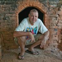 DIY: Paul Lorimer squats in front of a kiln he built near his home on the southeastern coast of Okinawa Island. Old school potter goes native in the wilds of southeast Okinawa