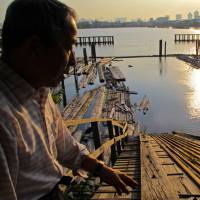 Liquid assets: Mitoyo Kamogawa, president of the Shin Kiba sawmill company Kamogawa Shoten, surveys logs he has stored afloat in Tokyo Bay, where they are safe from fire and insects and are easy to maneuver, while the soaking allays splitting. Blazing a woodland trail through Shin Kiba