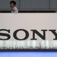 The big print: A man stands above a Sony Corp. sign at the company’s headquarters in Tokyo on May 22. Loeb Sony drive based on faith in Abe