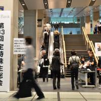 Shares and share alike: Softbank Corp. investors enter the venue for the annual shareholders’ meeting Friday morning at the Tokyo International Forum conference hall. Sprint part of Son's quest for the top