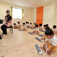 Attuned: Children at Byobugaura Harukaze Nursery take a music lesson June 4. Yokohama day care centers scramble to keep kids off waiting lists